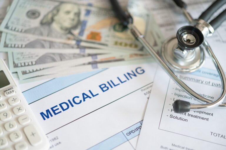 Medical billing documents with a stethoscope, calculator, and US hundred-dollar bills.