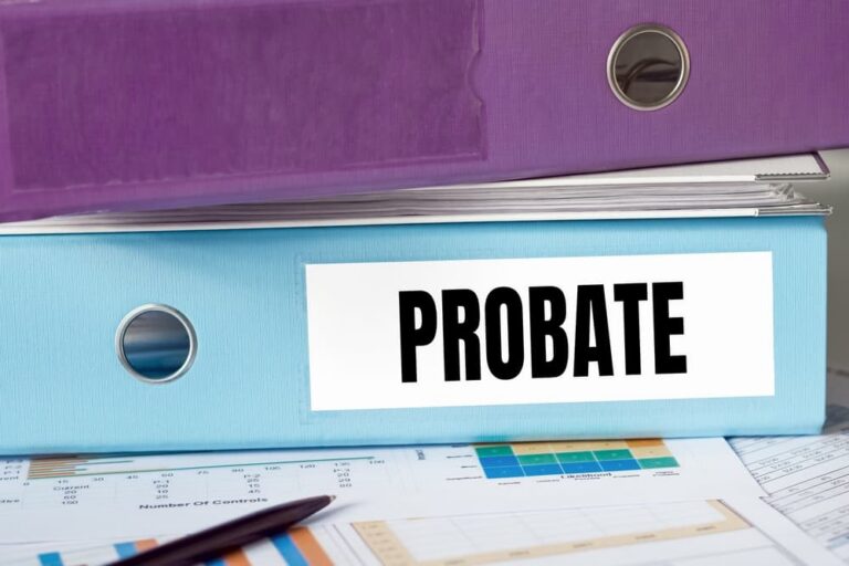 Close-up of blue binder labeled "PROBATE" underneath a purple binder, on top of financial documents.