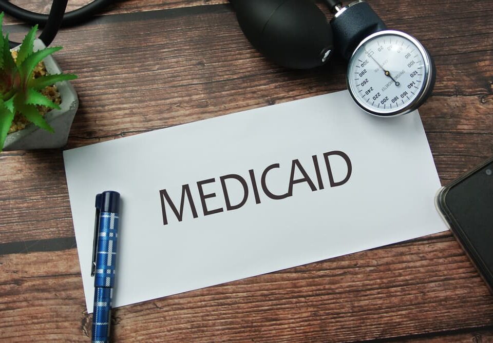 Selective focus of pen, sphygmomanometer, inscription with notebook written with MEDICAID.