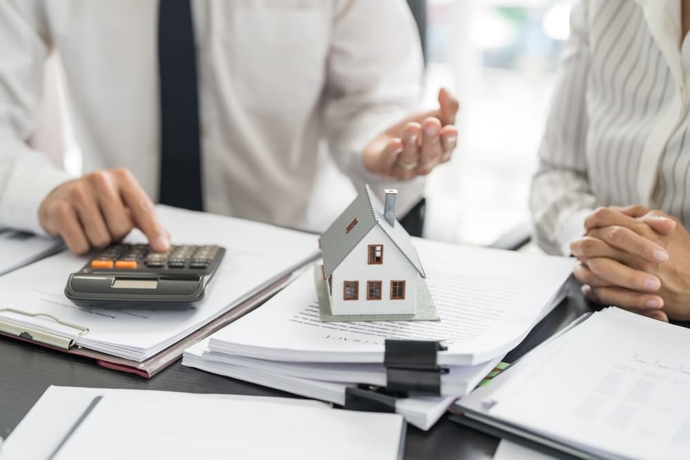 people signing contract making deal with real estate agent