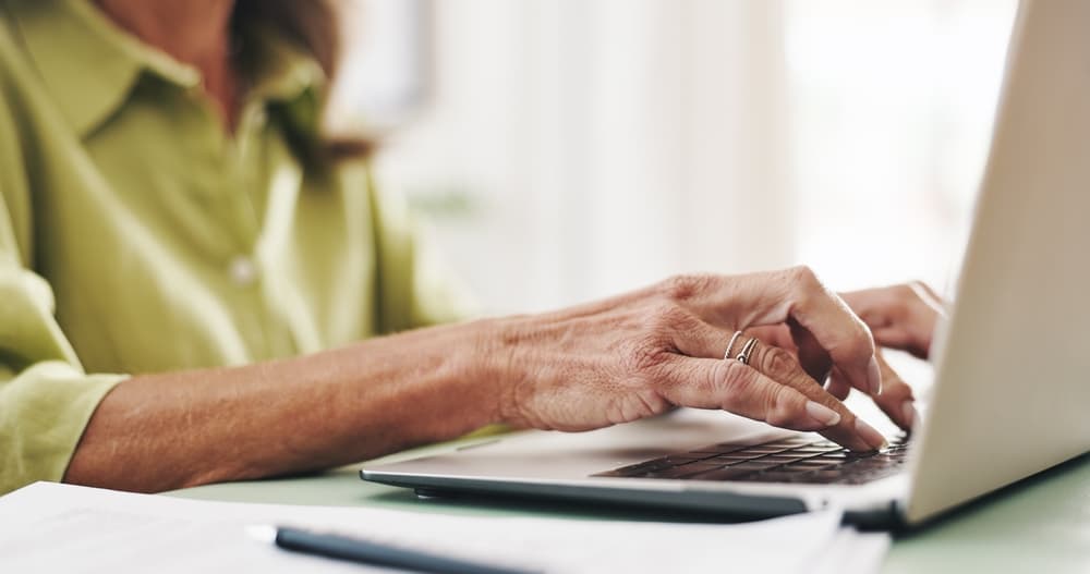Hands, typing and laptop with old woman at home for retirement fund savings, pensioner asset and budget.