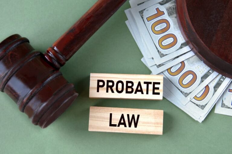 Wooden gavel, stacks of hundred-dollar bills, and wooden blocks with "PROBATE LAW" text on green background.